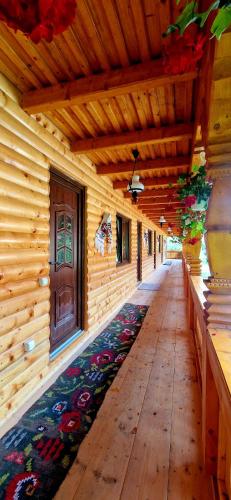 a hallway of a wooden house with a rug on the floor at Pensiunea Malinul in Bîrsana
