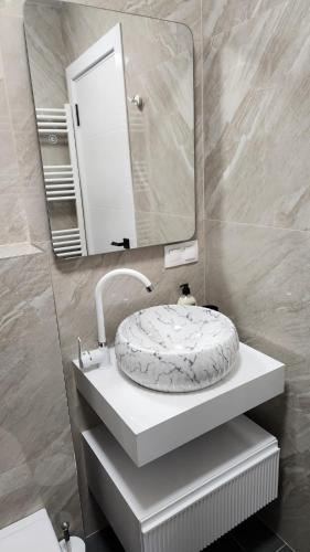 a bathroom with a sink and a mirror at Димоти Апартхотел in Sofia