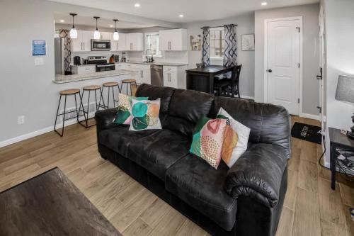 un soggiorno con divano in pelle nera e una cucina di Three bedroom family home with off street parking and fenced yard a Centennial