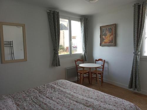 une chambre avec un lit, une table et une fenêtre dans l'établissement Maison de bourg, à Mauléon
