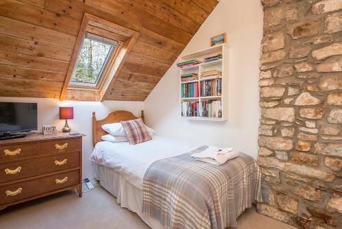 ein Schlafzimmer mit einem Bett und einer Steinwand in der Unterkunft Pwll Cottage in Carmarthen