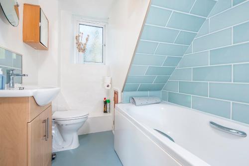 ein Badezimmer mit Badewanne, Toilette und Waschbecken in der Unterkunft Pwll Cottage in Carmarthen