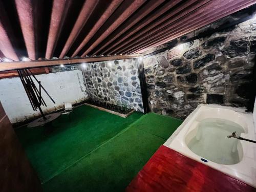 a room with a bath tub and a green floor at Casa Amanda in Villa de Alvarez