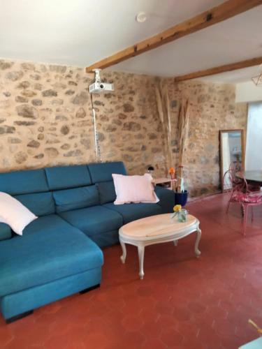 un salon avec un canapé bleu et une table basse dans l'établissement Charmante maison avec piscine proche de la mer, à Sorède