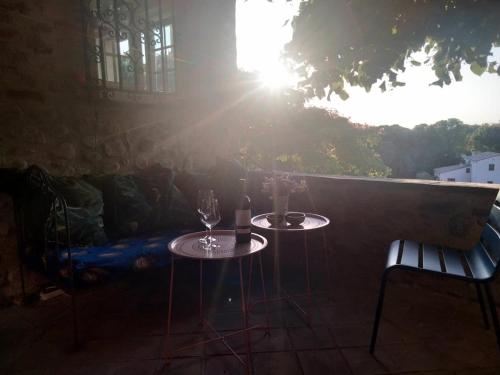 - deux tables avec des verres à vin assises sur une terrasse dans l'établissement Charmante maison avec piscine proche de la mer, à Sorède
