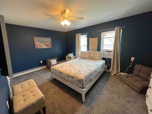 ein Schlafzimmer mit einem Bett, einem Sofa und einem Deckenventilator in der Unterkunft Blue Anchor Estate-BEACH BLOCK in the Orange Loop in Atlantic City