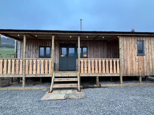 a wooden cabin with a door and a ladder in front at Dark Skies den in Fryup