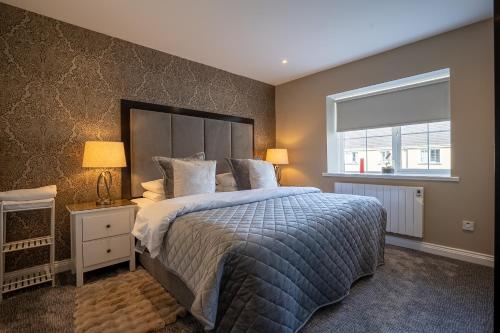 a bedroom with a large bed and a window at Muckross Luxury Residences in Killarney