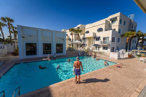 a man standing in the swimming pool at a resort at Enchanting 2-Bedroom Ground Floor Beach Condo at Cape Canaveral WiFi & AC in Cape Canaveral