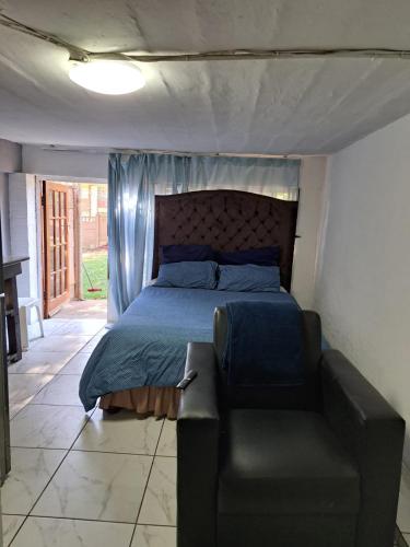a bedroom with a bed and a couch in it at PMB Backpackers Lodge in Pietermaritzburg