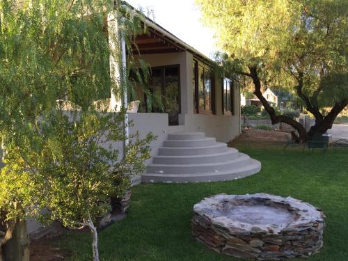 a house with a set of stairs in a yard at Matjiesvlei Cottages in Calitzdorp