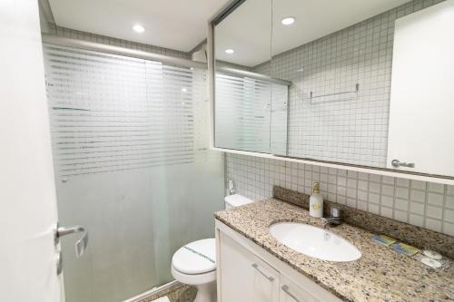 a bathroom with a sink and a toilet and a mirror at OZPED Flats Particulares Edifício Life Resort in Brasilia