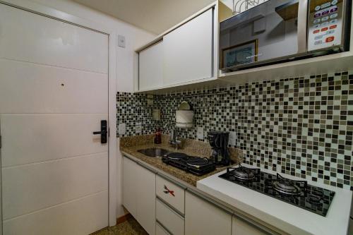 a small kitchen with a sink and a stove at OZPED Flats Particulares Edifício Life Resort in Brasilia