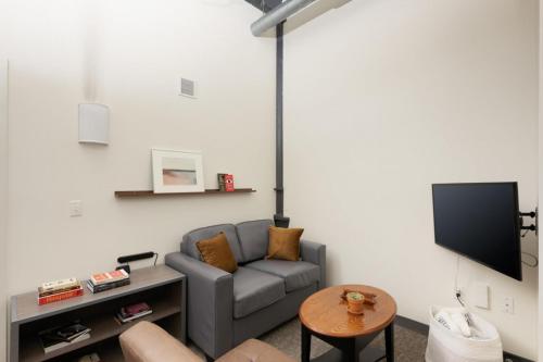a living room with a couch and a tv at Cream City 2BR Apt - Just 3 Blocks to Fiserv with Gym and Parking in Milwaukee