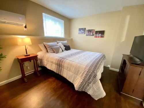 a bedroom with a bed and a lamp and a television at Like Home at Fairmont in Lexington