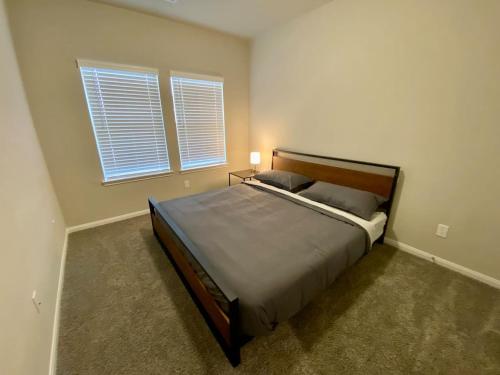 a bedroom with a bed and two windows at 4-BR Getaway Ideal for Families in Richmond