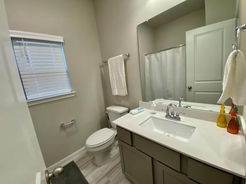 a bathroom with a sink and a toilet and a mirror at 4-BR Getaway Ideal for Families in Richmond