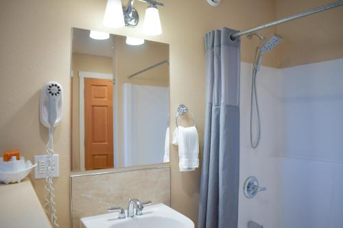 Un baño con lavabo y ducha con espejo. en Lakeshore Lodging Lodge 722, en Homer