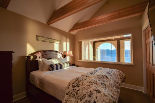 Un dormitorio con una cama grande con ventana. en Lakeshore Lodging Lodge 722, en Homer