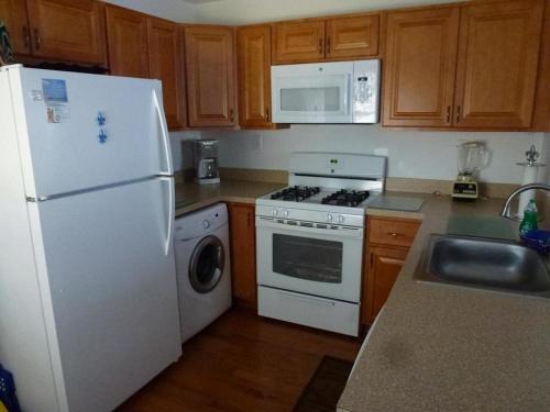 eine Küche mit einem weißen Kühlschrank und einem Geschirrspüler in der Unterkunft Ocean Block Beach Badges Cute Cottage In The Oceanblock No Streets To Cross 7 Houses To The Ocean Rear Cottage 13048 in Surf City