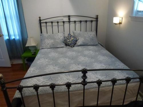ein Bett mit einem Metallrahmen und Kissen darauf in der Unterkunft Ocean Block Beach Badges Cute Cottage In The Oceanblock No Streets To Cross 7 Houses To The Ocean Rear Cottage 13048 in Surf City