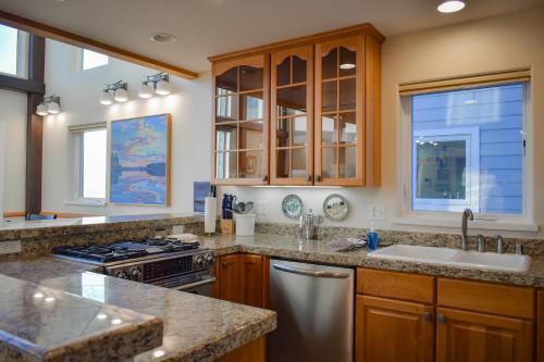 una cocina con fregadero y estufa en Lakeshore Lodging Lodge 715, en Homer