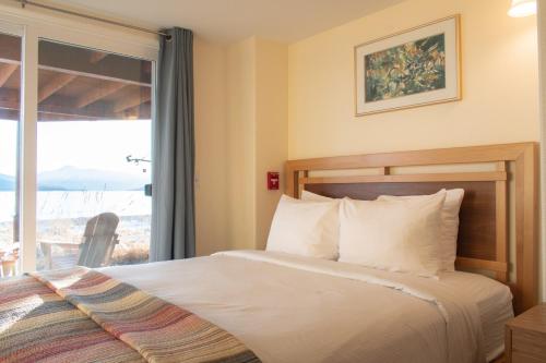 Una habitación de hotel con una cama y una ventana. en Lakeshore Lodging Lodge 613, en Homer