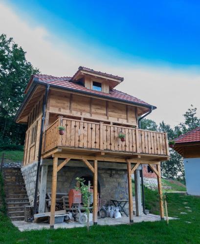 a large wooden house with a fireplace in a yard at Etno Zvuk Tisine Djukic in Valjevo