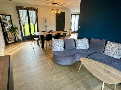 un salon avec un canapé bleu et une table dans l'établissement Maison de plain pied 3 chambres, à Saint-Viance
