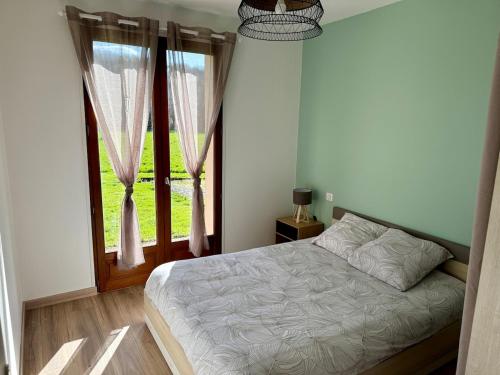 une chambre avec un lit et une grande fenêtre dans l'établissement Maison de plain pied 3 chambres, à Saint-Viance