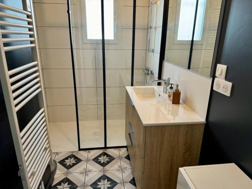 une salle de bain avec un lavabo et une douche dans l'établissement Maison de plain pied 3 chambres, à Saint-Viance