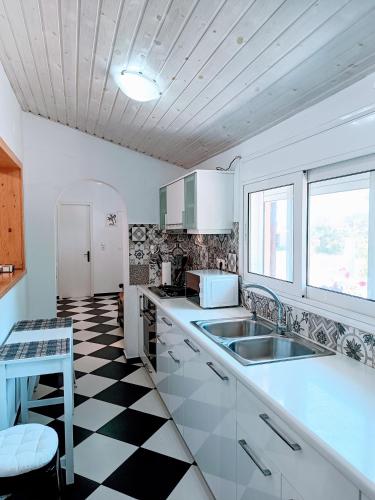 a kitchen with a black and white checkered floor at House Konstantinos in Agios Georgios