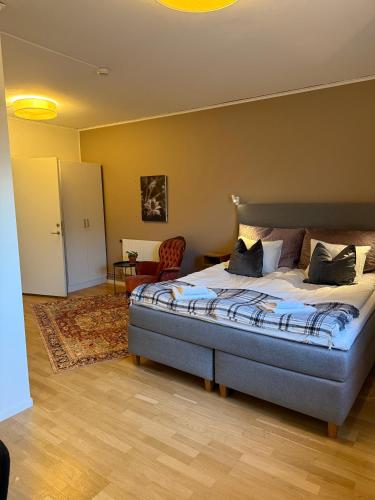 a bedroom with a bed and a chair in it at Rindö Hamn Bed & Breakfast in Vaxholm