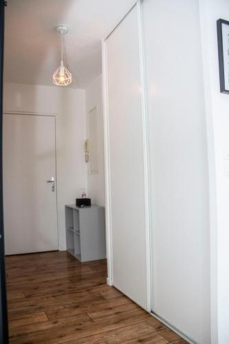 a room with white walls and a hallway with a closet at Studio parking wifi Disney 5mn Val d'Europe in Montévrain