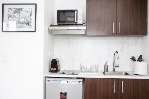 a kitchen with a sink and a microwave at Studio parking wifi Disney 5mn Val d'Europe in Montévrain