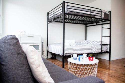a living room with two bunk beds and a couch at Studio parking wifi Disney 5mn Val d'Europe in Montévrain