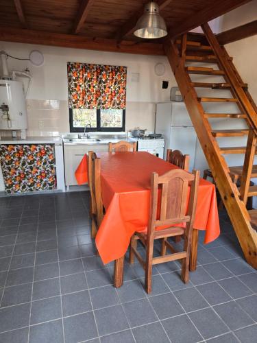a kitchen with an orange table and chairs in a kitchen at Miniloft Centrico in El Calafate