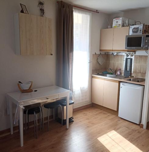 une petite cuisine avec une table et des chaises dans l'établissement Appartement cosy 4 couchages -Pont du Verdon- centre station, à La Foux