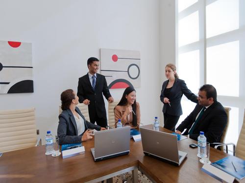 a group of people standing around a table at Novotel Abu Dhabi Gate in Abu Dhabi