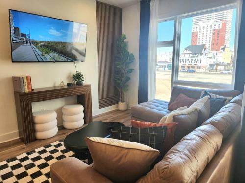 a living room with a couch and a tv at The James Suite One-Newly Built, 2 BR, Beach Block in Atlantic City