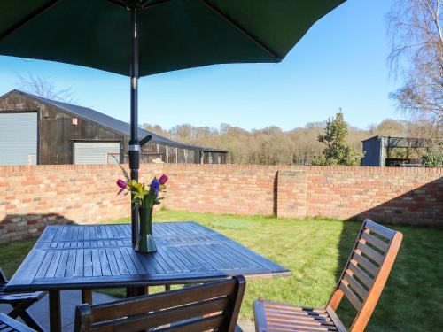 a blue table with a vase of flowers on it at The Cowshed in Battle