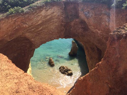 a view of the ocean through a rock cave at Apartamento Praia do Vau in Alvor