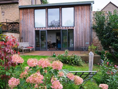 a house with glass doors and flowers in the yard at Atelierhaus in Rehborn
