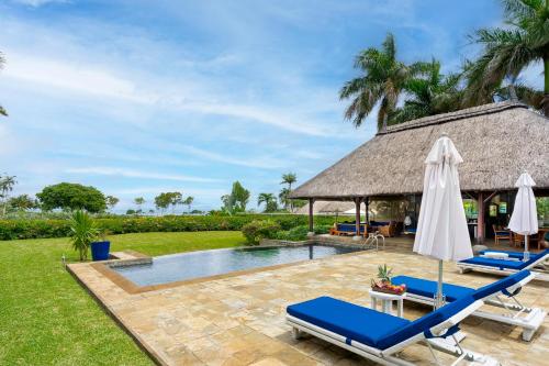 a resort pool with lounge chairs and an umbrella at Villa Ebony -Tropical Design with Ocean Views, 5-star resort in Albion