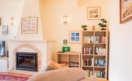 a living room with a fireplace and a book shelf at Casa Bellarosa in Raposeira