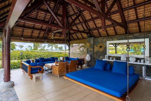 a room with a bed and chairs and a table at Villa Ebony -Tropical Design with Ocean Views, 5-star resort in Albion