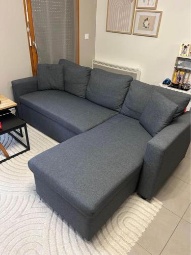 - un canapé bleu dans le salon dans l'établissement grand et beau appartement, à Colombes