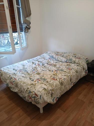 - un lit dans une chambre avec couverture dans l'établissement grand et beau appartement, à Colombes