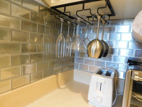 una encimera de cocina con ollas y sartenes colgadas de una pared en Sunset 205, sleeps six, next door to the pool, 100m to the beach!, en Jacó