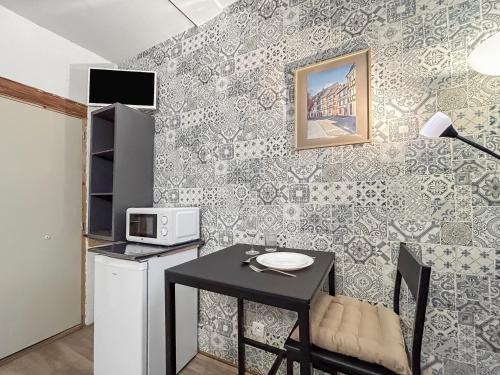 une petite cuisine avec une table et un micro-ondes dans l'établissement La Provence Studio, à Colmar